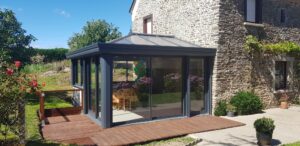 Véranda aluminium avec volets roulants près de saint malo